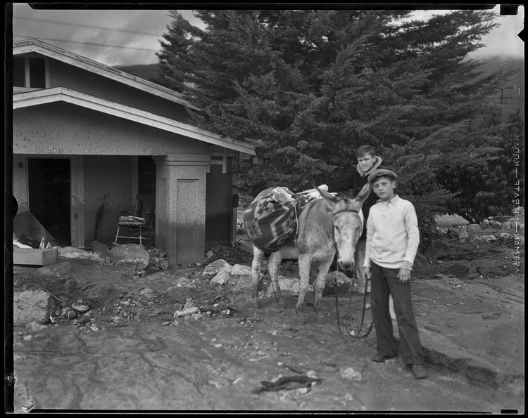 Donkey and two boys next to a house damaged by the catastrophic January flood and mudslide, La Crescenta-Montrose, 1934